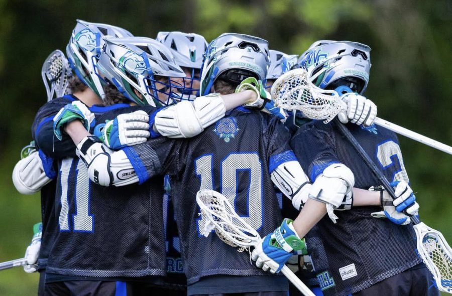 The team celebrates on-field in a huddle after winning the country championship on May 8, 2023. The win this year has made them back-to-back champions.