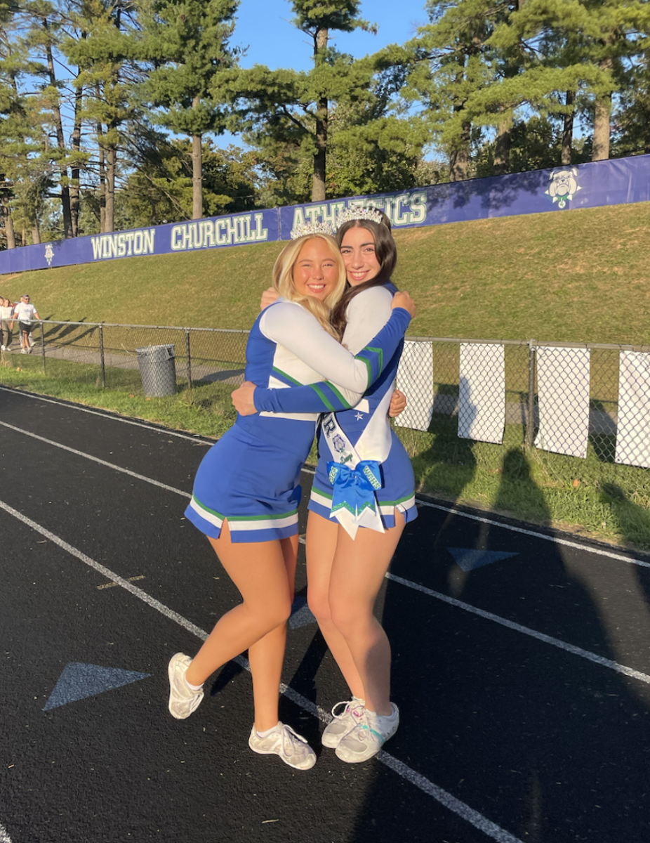 WCHS senior Sophie Michnick hugs her teammate as they get ready to cheer for the first WCHS home football game on October 12, 2023.