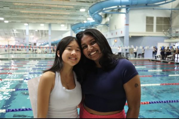 WCHS senior Sabrina Chou poses with a fellow swim manager at a Varsity swim and dive meet. 
