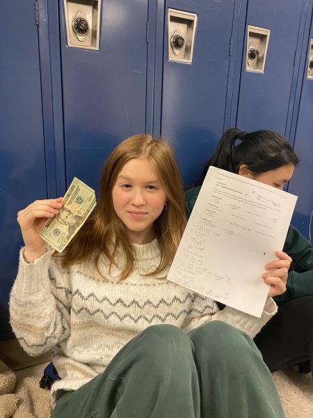 WCHS sophomore Catherine Ward smiles after receiving a $20 bill for acing her math test. The new MCPS Learn to Earn program awards students with monetary incentive for academic excellence.
