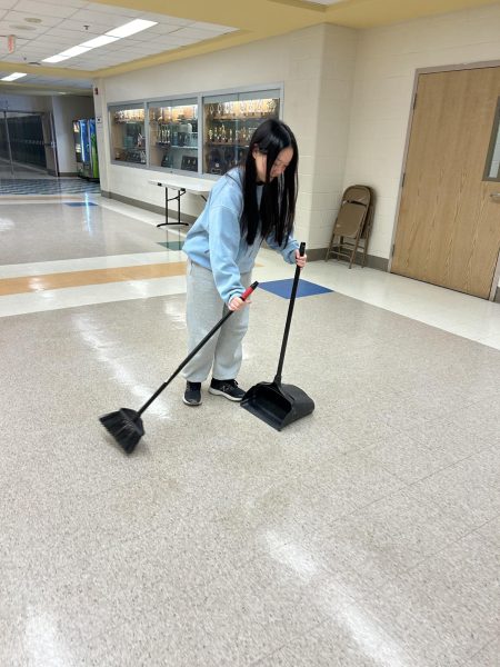 After being swept in a hall swee, WCHS senior Kalena Yee sweeps the hall as a penalty for tardiness.