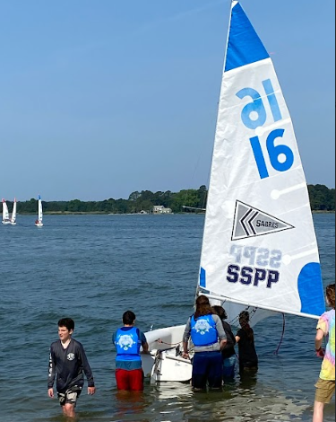 WCHS sailing team members Jack Brinsfeild and Erez Engler get ready to set sail as they push the boat into the water.
