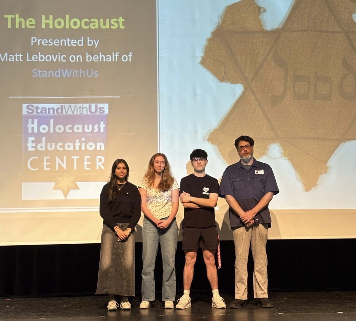 Holocaust Education Center founding director Matt Lebovic and WCHS seniors Ila Benitah, Leah Kreisler and Josh Feldman pose on the WCHS auditorium stage following Lebovic's April 24 assembly on the Holocaust. 