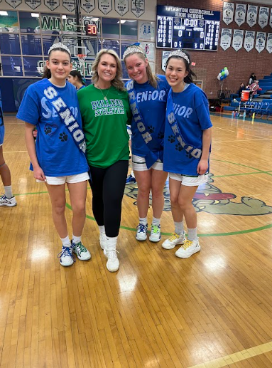 Kinsey Gunn, WCHS athletic trainer, poses alongside the Varsity Girls Basketball team's seniors following a successful senior night victory.