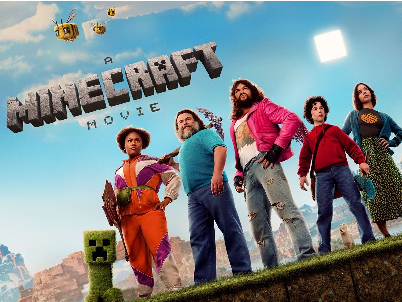 A promotional photo for "A Minecraft Movie" featuring Jason Momoa, Jack Black, and other major cast members.	