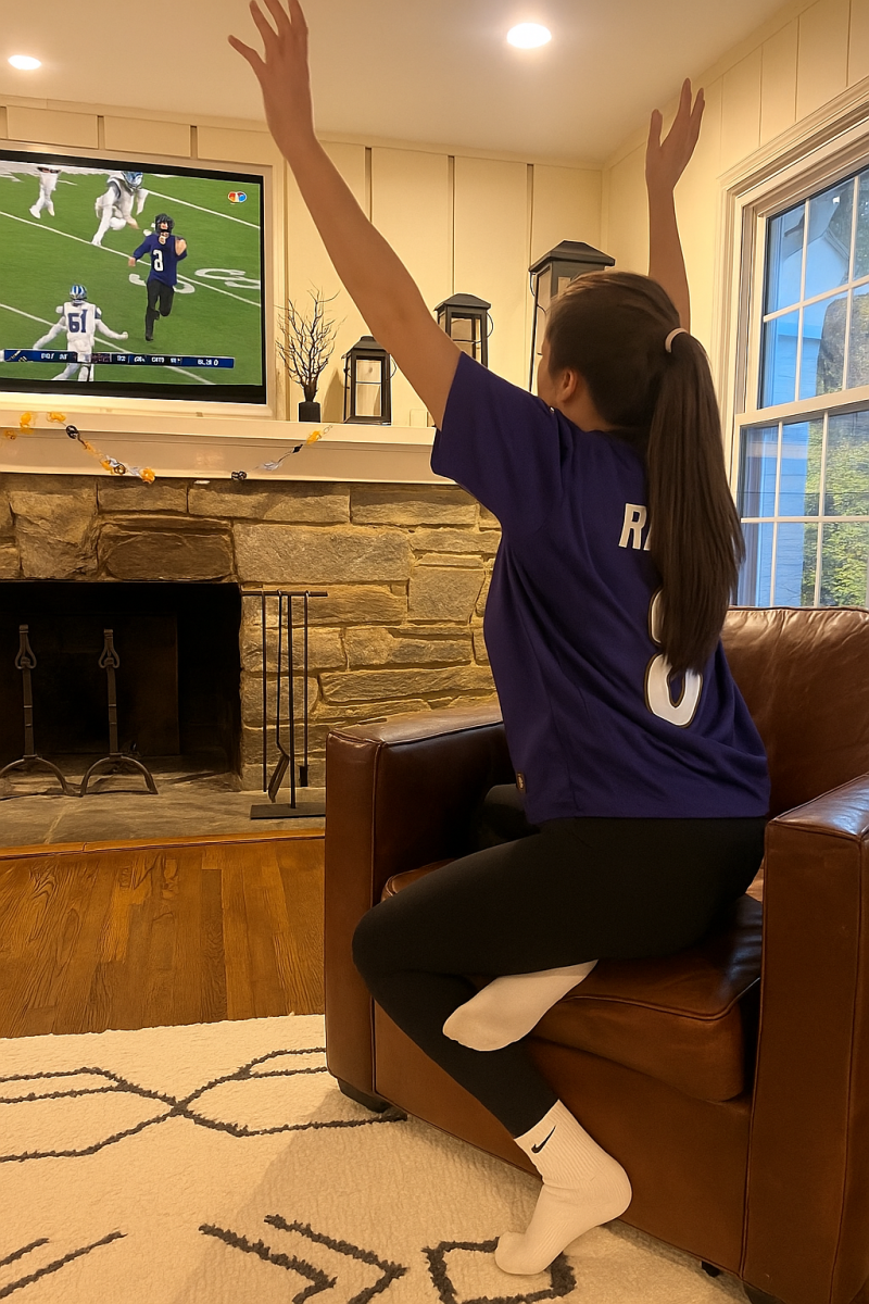 WCHS Sophomore Sophie Finkleman, dressed in her Ravens jersey, cheers on the Ravens during their Sunday night game. This Sunday ritual strengthens their bond as they cheer for their favorite team, creating lasting memories with each play.