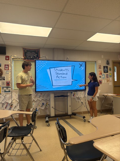Seniors Evie Namath and Luke Molinaro welcome students to their first Students Demand Action meeting of the school year. They hope to educate students on gun violence and advocate for change.