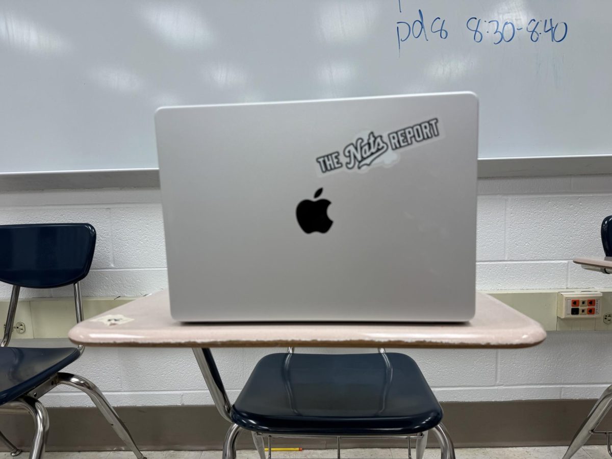 A WCHS freshman uses a MacBook Pro before class, finishing his work that could not be completed on a chromebook before the bell rings. The new policy would require him to put the device away when class starts.