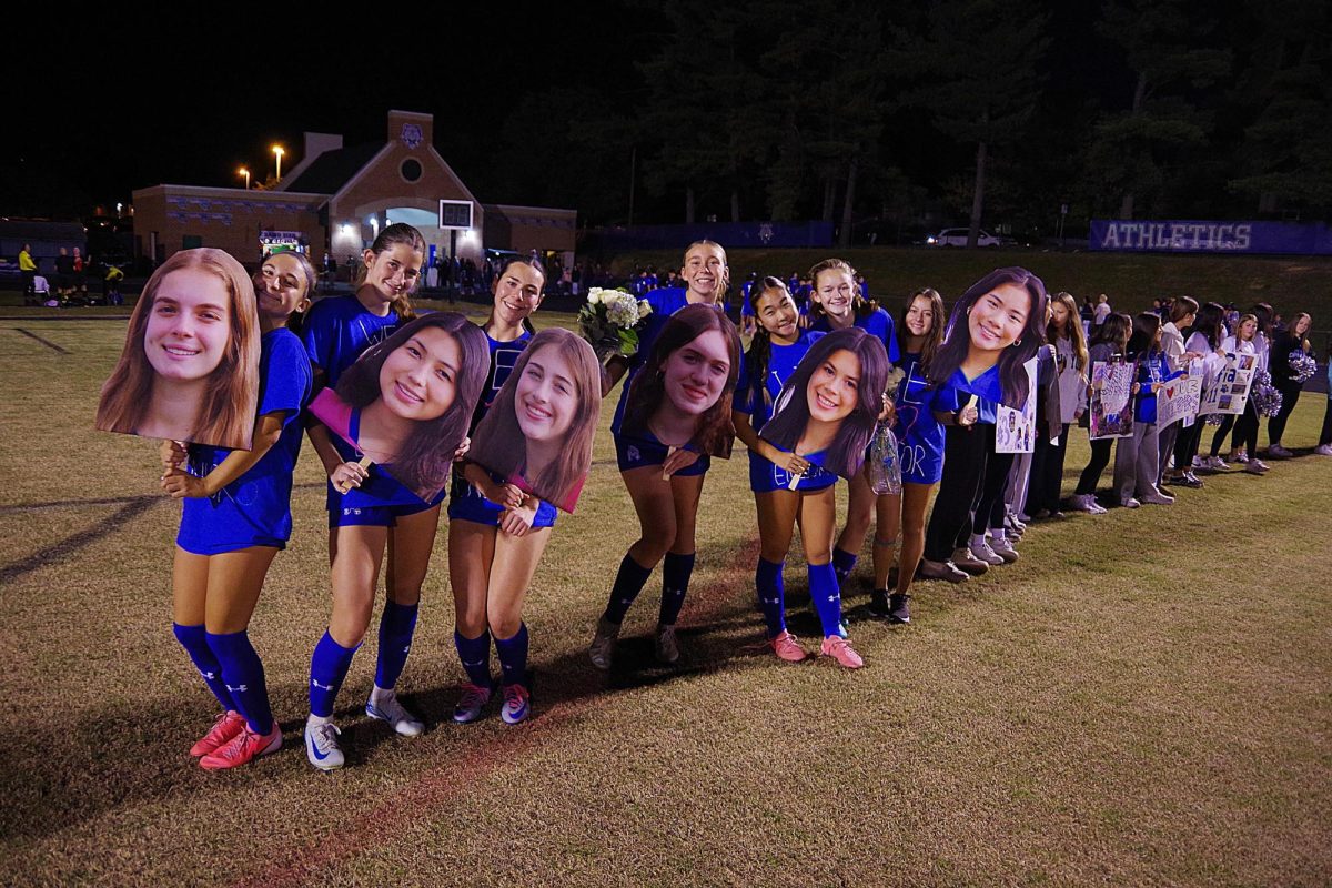 The Varsity Girls Soccer team lines up to honor the Class of 2025 during their senior night on October 18, 2024. The team holds cardboard cutouts of the senior class and wears handcrafted senior shirts.
