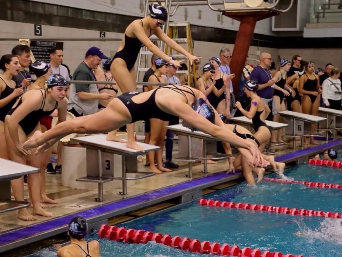 WCHS Varsity Swim and Dive captain Lia Kudelko dives into the pool during an event. Kudelko must manage her course load and extracurricular activities with her year-round swim.