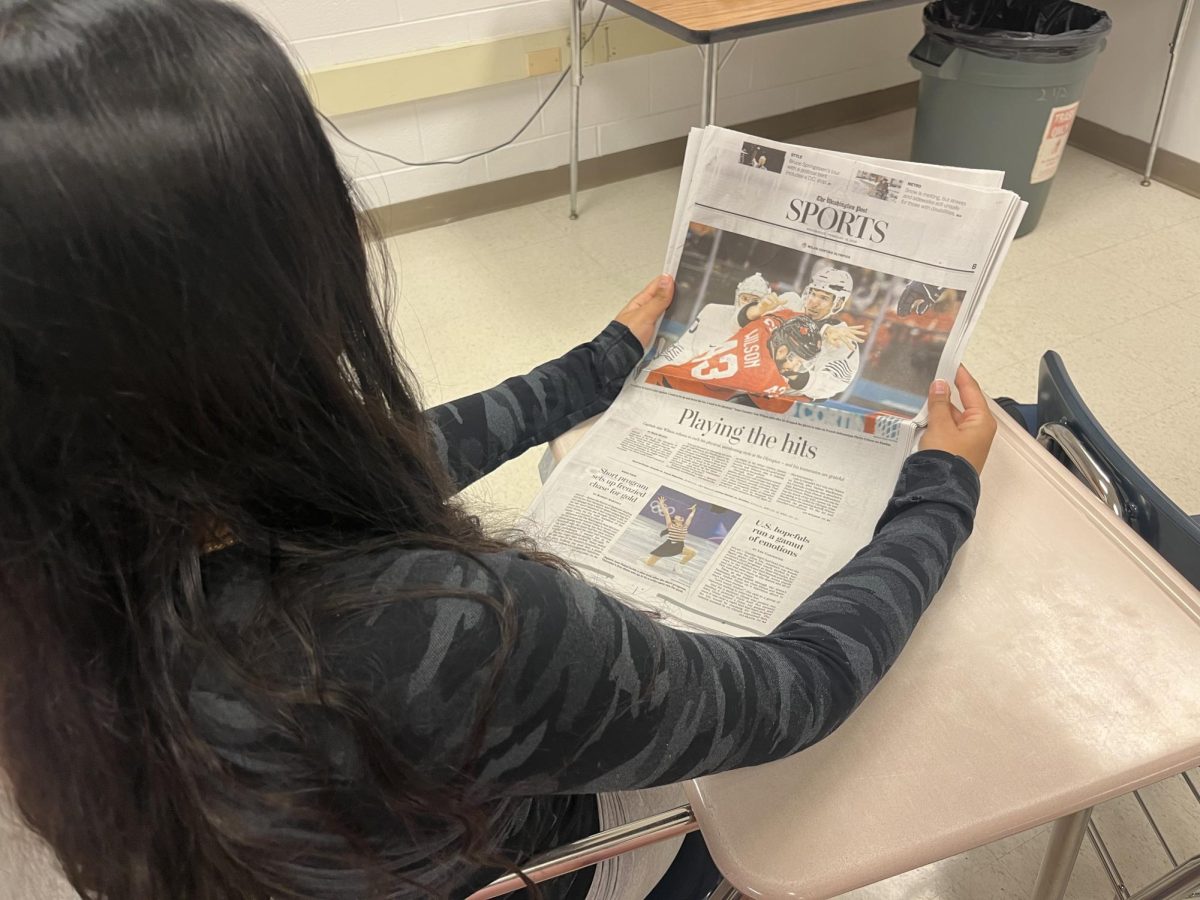 WCHS senior Alisha Durbhakula reads a Washington Post article about Olympic ice hockey. While the standalone sports section was eliminated, there is still some coverage of sports as a "cultural phenomenon."
